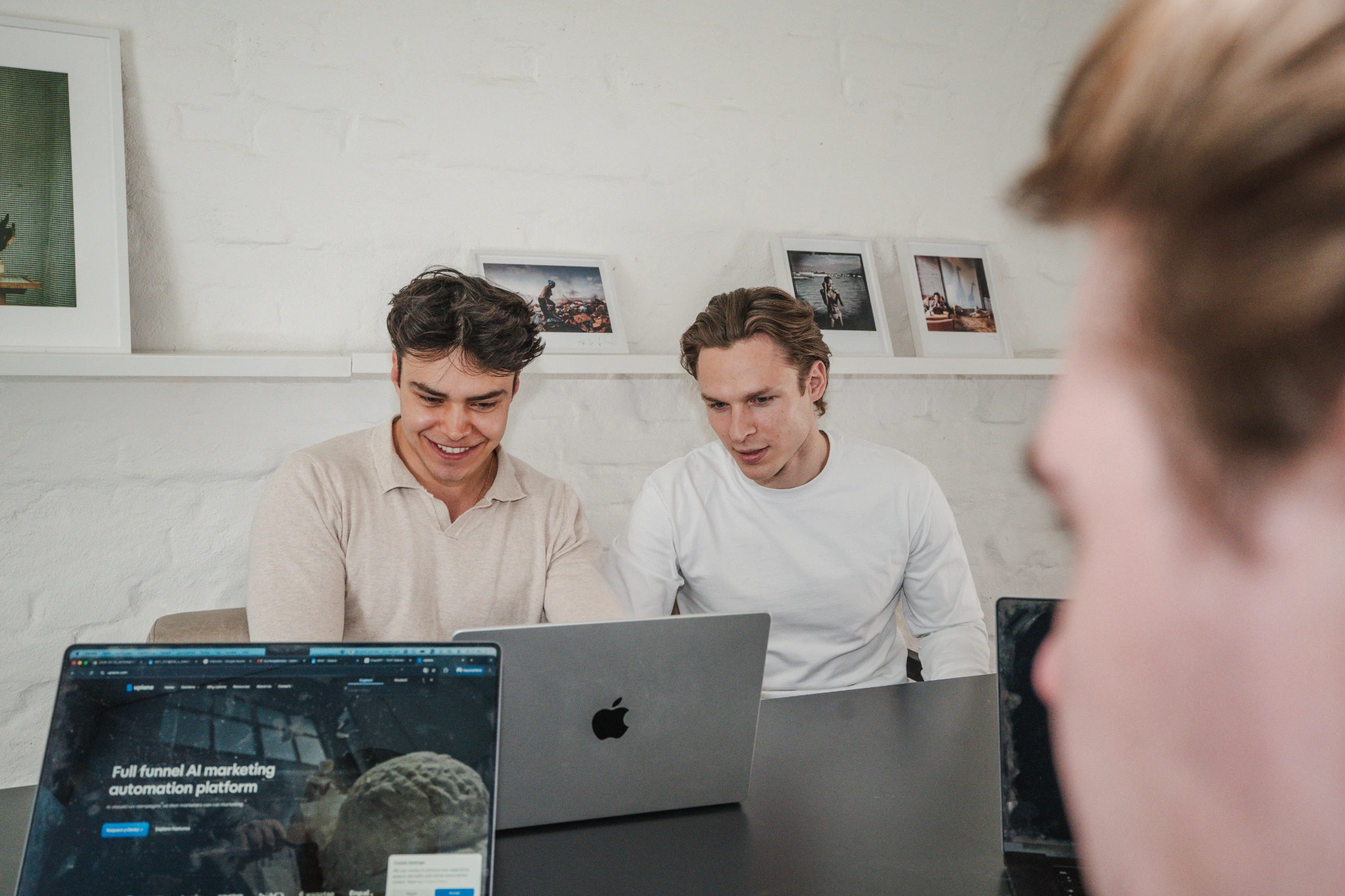 Three Uplane team members collaborating around laptops