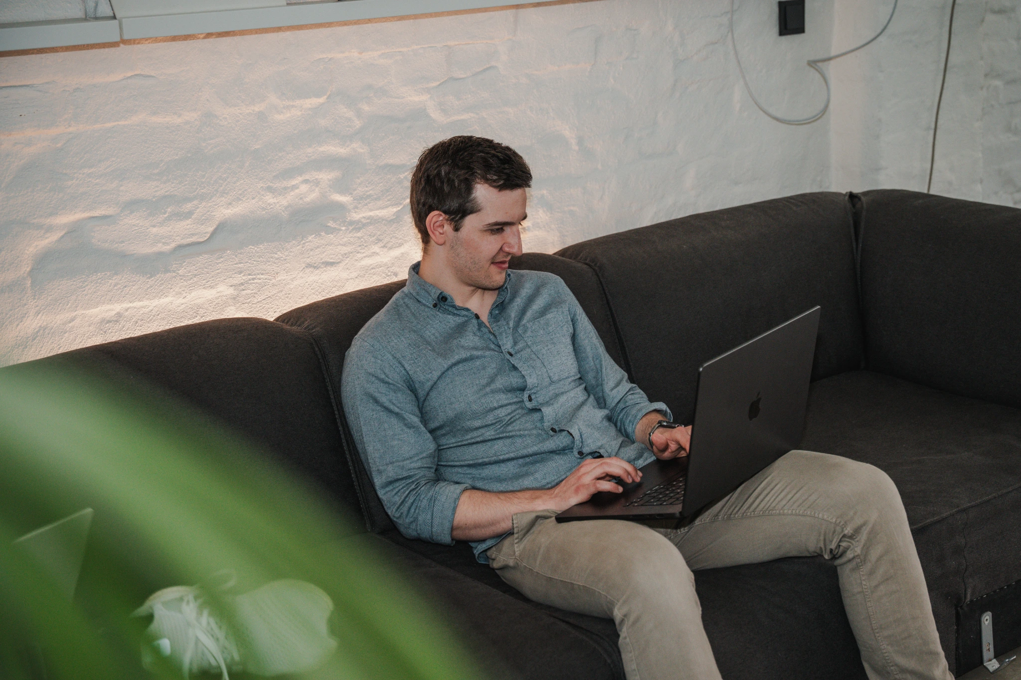 A Uplane team member working from an office sofa